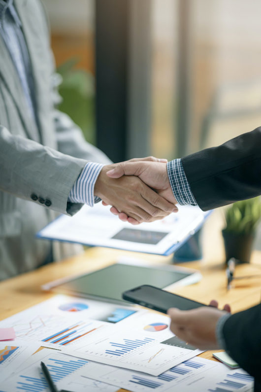 Two Businessman handshake for teamwork of business merger and acquisition at office.